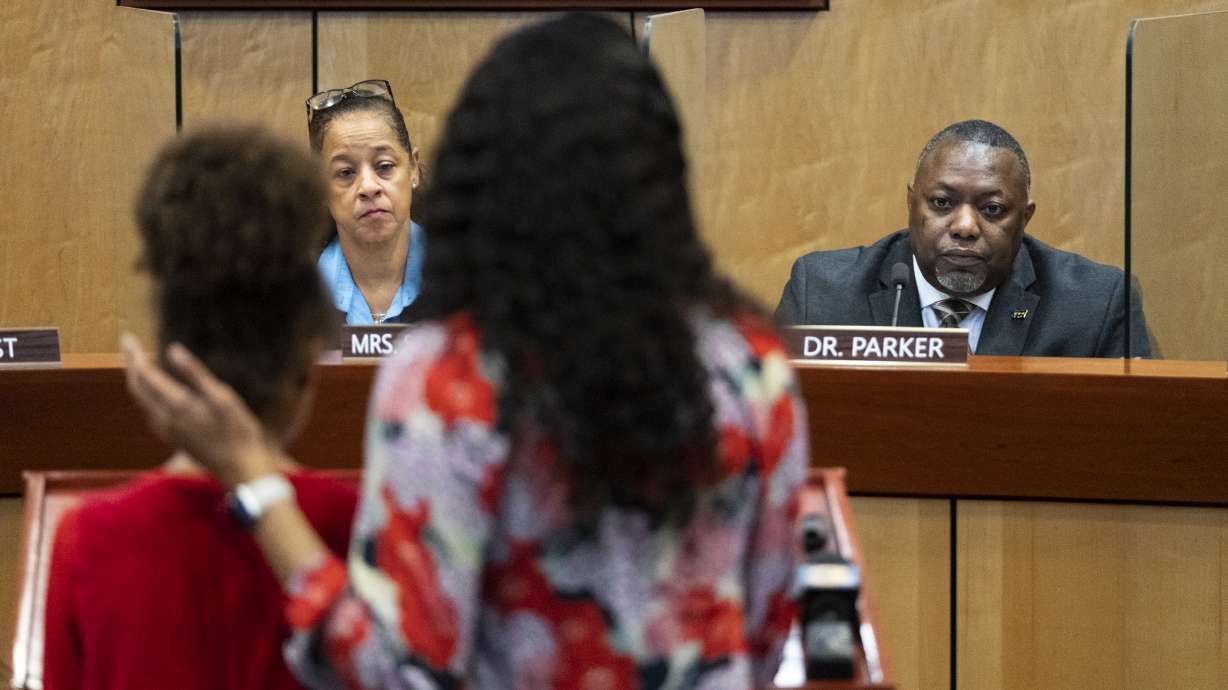 Teacher Djifa Lee, center, stands with her daughter as she speaks in front of the Newport News School Board on Tuesday. As kids' behavior reaches crisis points after the stress and isolation of pandemic shutdowns, many schools are facing pressure to rethink discipline approaches.