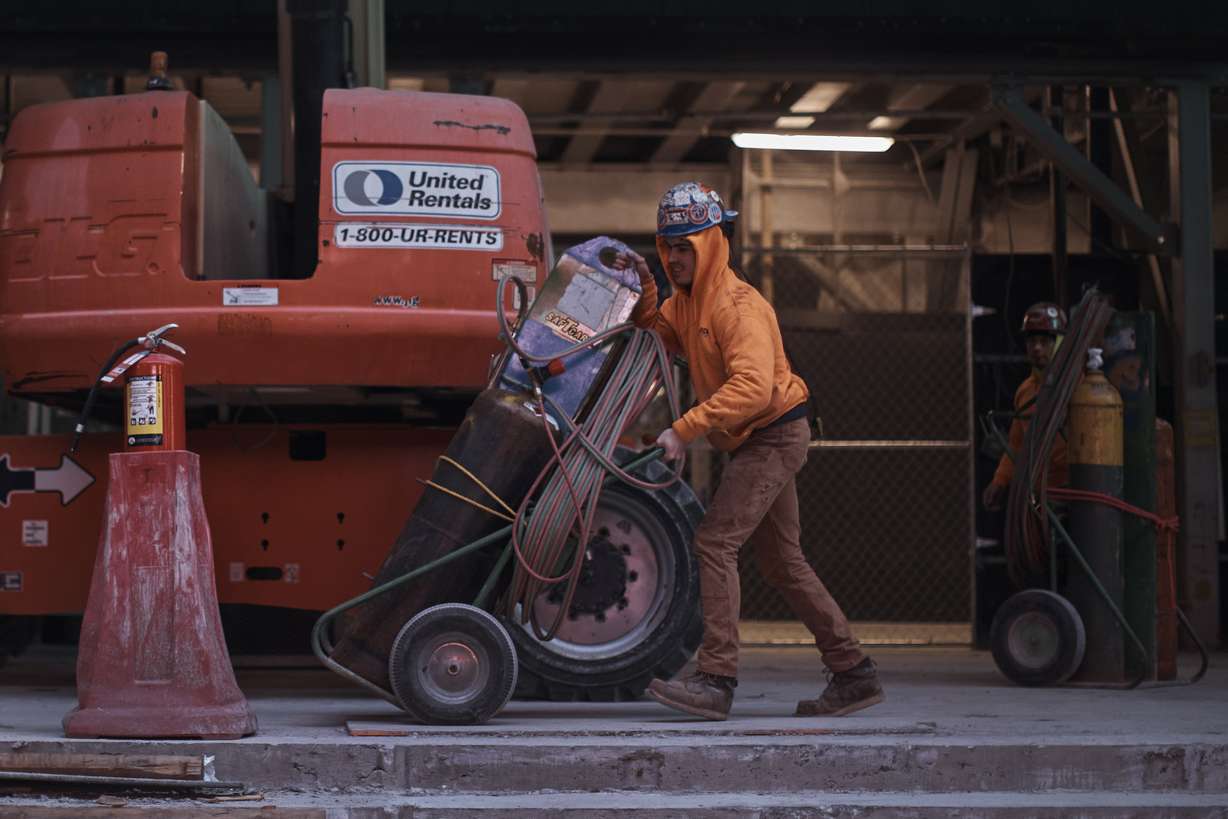 Construction workers handle equipment on Jan. 17, in New York. After the relative quiet of the pandemic, New York City has come roaring back.