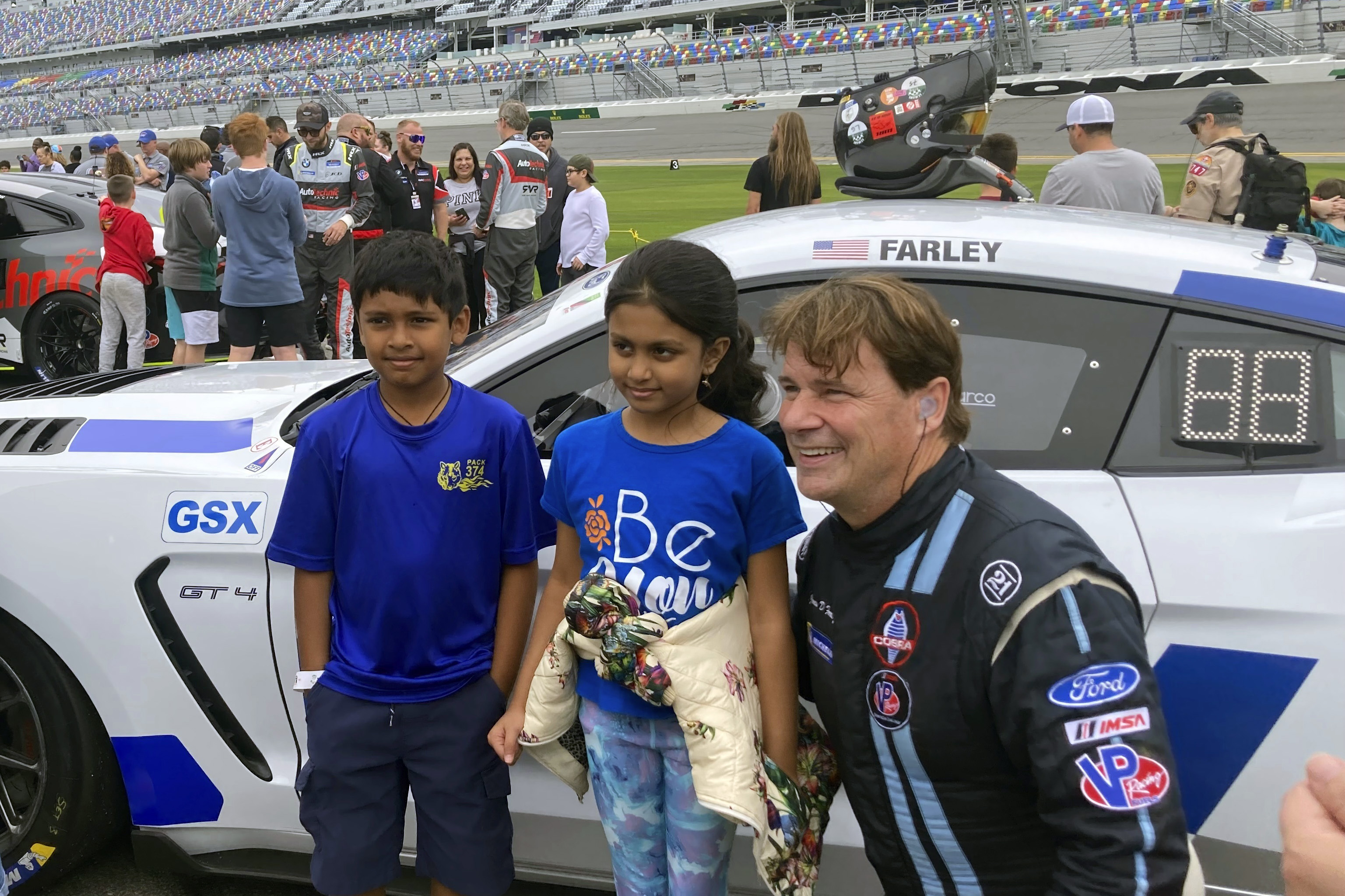 Ford CEO Jim Farley posing with fans on at Daytona International Speedway, Saturday, Jan. 21, 2023, in Daytona Beach, Fla., ahead of the IMSA Vo Racing SportsCar Challenge motor race. It was the professional racing debut for the 60-year-old chief executive of Ford Motor Co. He finished 12th.