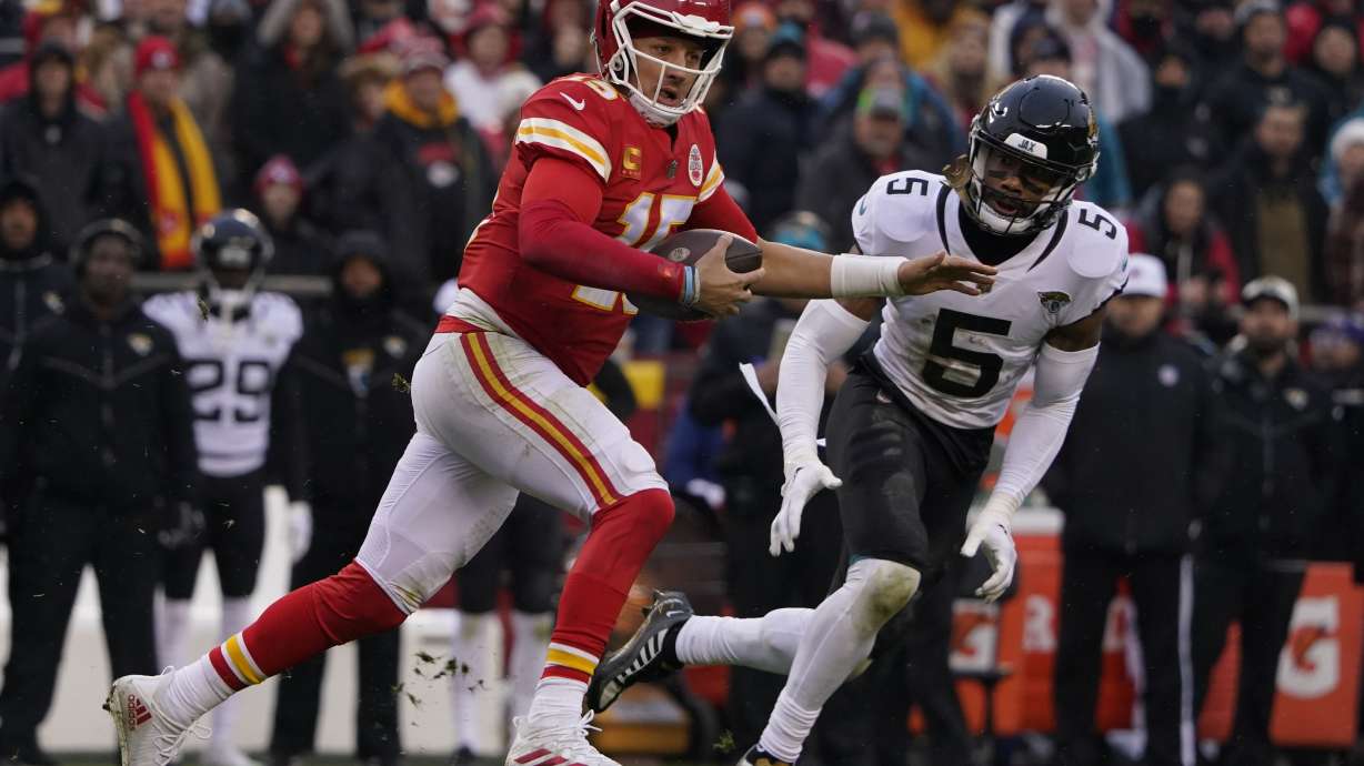 Kansas City Chiefs quarterback Patrick Mahomes (15) runs out of the pocket as Jacksonville Jaguars safety Andre Cisco (5) defends during the first half of an NFL divisional round playoff football game, Saturday, Jan. 21, 2023, in Kansas City, Mo. Mahomes was injured after the play.