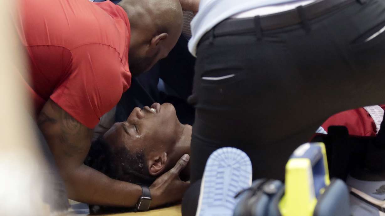 North Carolina State player Terquavion Smith, bottom, is tended by medical personnel after he crashed to the floor after being fouled during the second half of an NCAA college basketball game against North Carolina, Saturday, Jan. 21, 2023, in Chapel Hill, N.C.