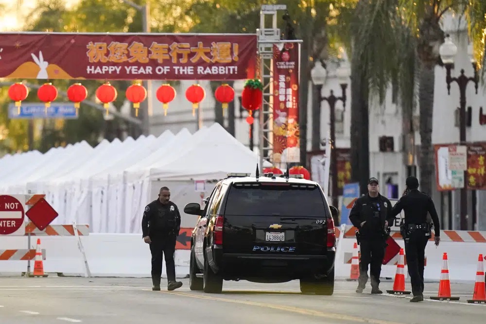 Police officers stand outside a ballroom dance club in Monterey Park, Calif., Sunday, . A mass shooting took place at a dance club following a Lunar New Year celebration, setting off a manhunt for the suspect.