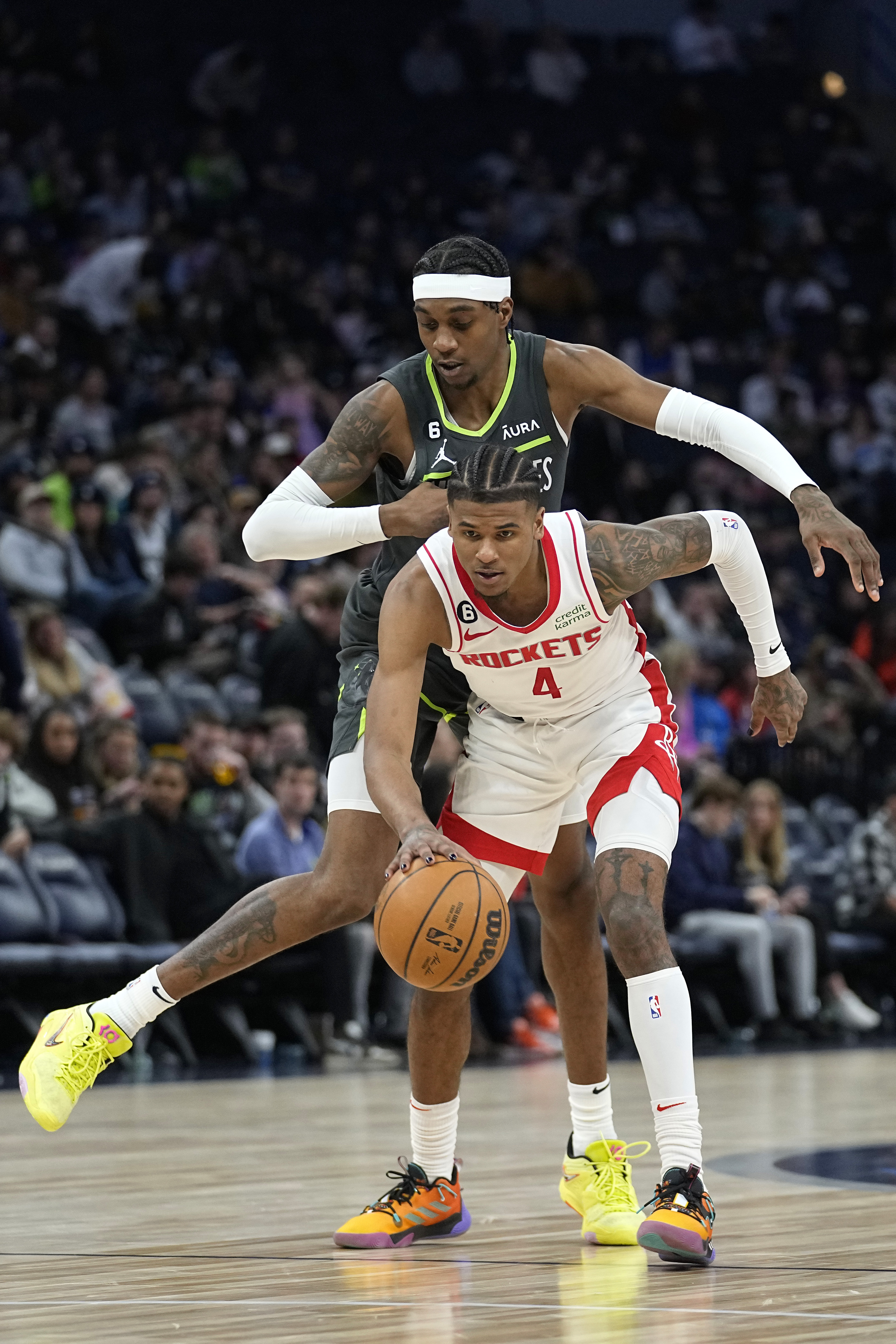 Houston Rockets guard Jalen Green (4) handles the ball while defended by Minnesota Timberwolves forward Jaden McDaniels (3) during the second half of an NBA basketball game, Saturday, Jan. 21, 2023, in Minneapolis. 
