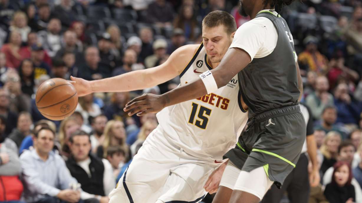 Denver Nuggets center Nikola Jokic, left, drives against Minnesota Timberwolves center Naz Reid during the second half of an NBA basketball game Wednesday, Jan. 18, 2023, in Denver.
