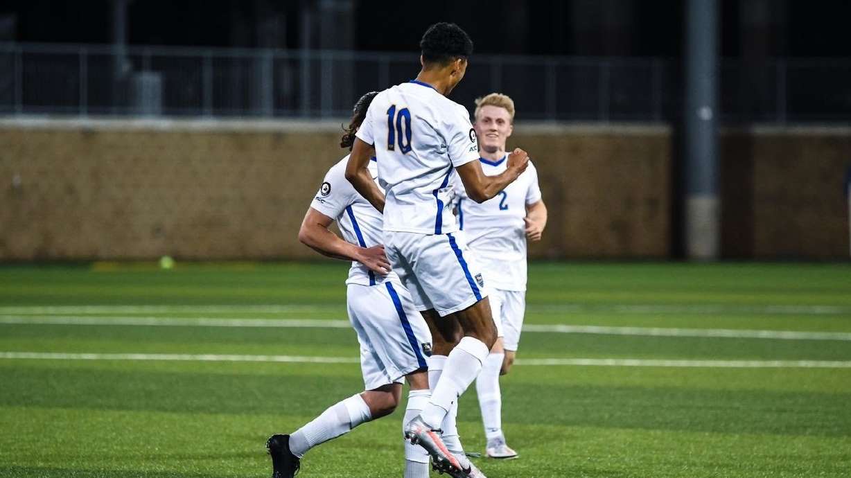 Bertin Jacquesson, No. 10, celebrates a goal with Jasper Loffelsend, right, looking on.