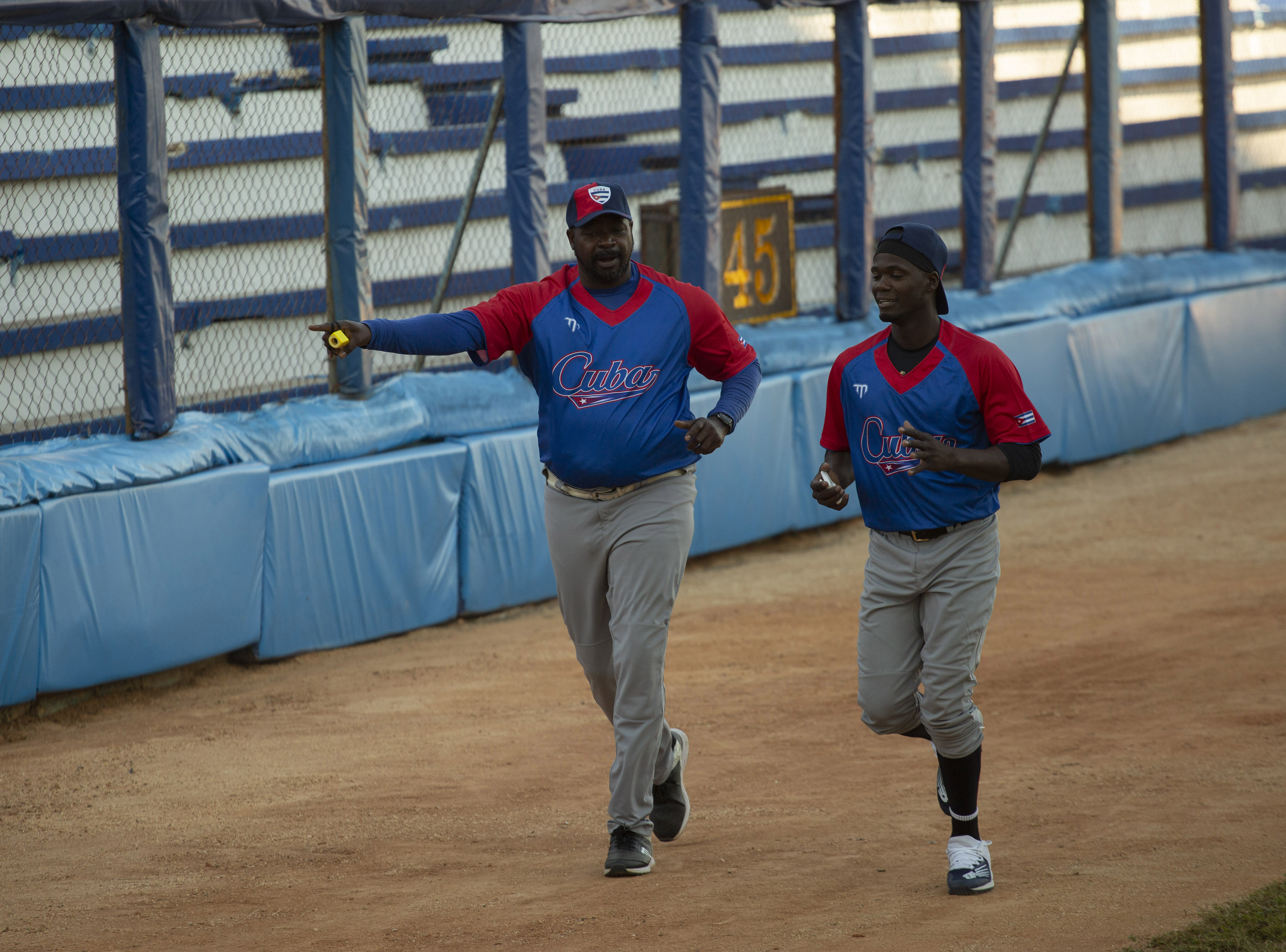 Batting coach Pedro Luis Lazo, left, and pitcher Livan Moinelo warm up as Cuban national baseball team hopefuls begin training at Latinoamericano stadium, preparing for the 2023 World Baseball Classic, in Havana, Cuba, Monday, Jan. 16, 2023. 
