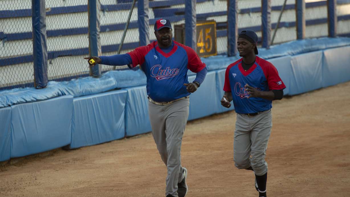 Batting coach Pedro Luis Lazo, left, and pitcher Livan Moinelo warm up as Cuban national baseball team hopefuls begin training at Latinoamericano stadium, preparing for the 2023 World Baseball Classic, in Havana, Cuba, Monday, Jan. 16, 2023.