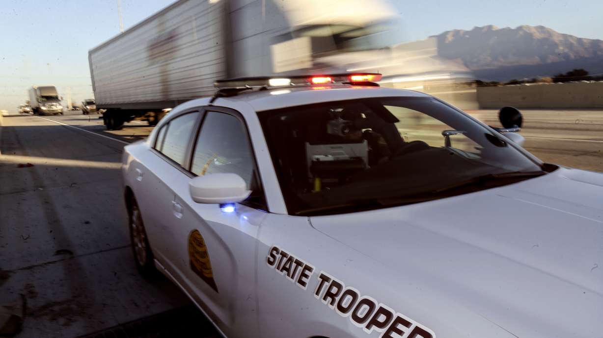A Utah Highway Patrol trooper searches for information on his computer on I-15 in Utah County.