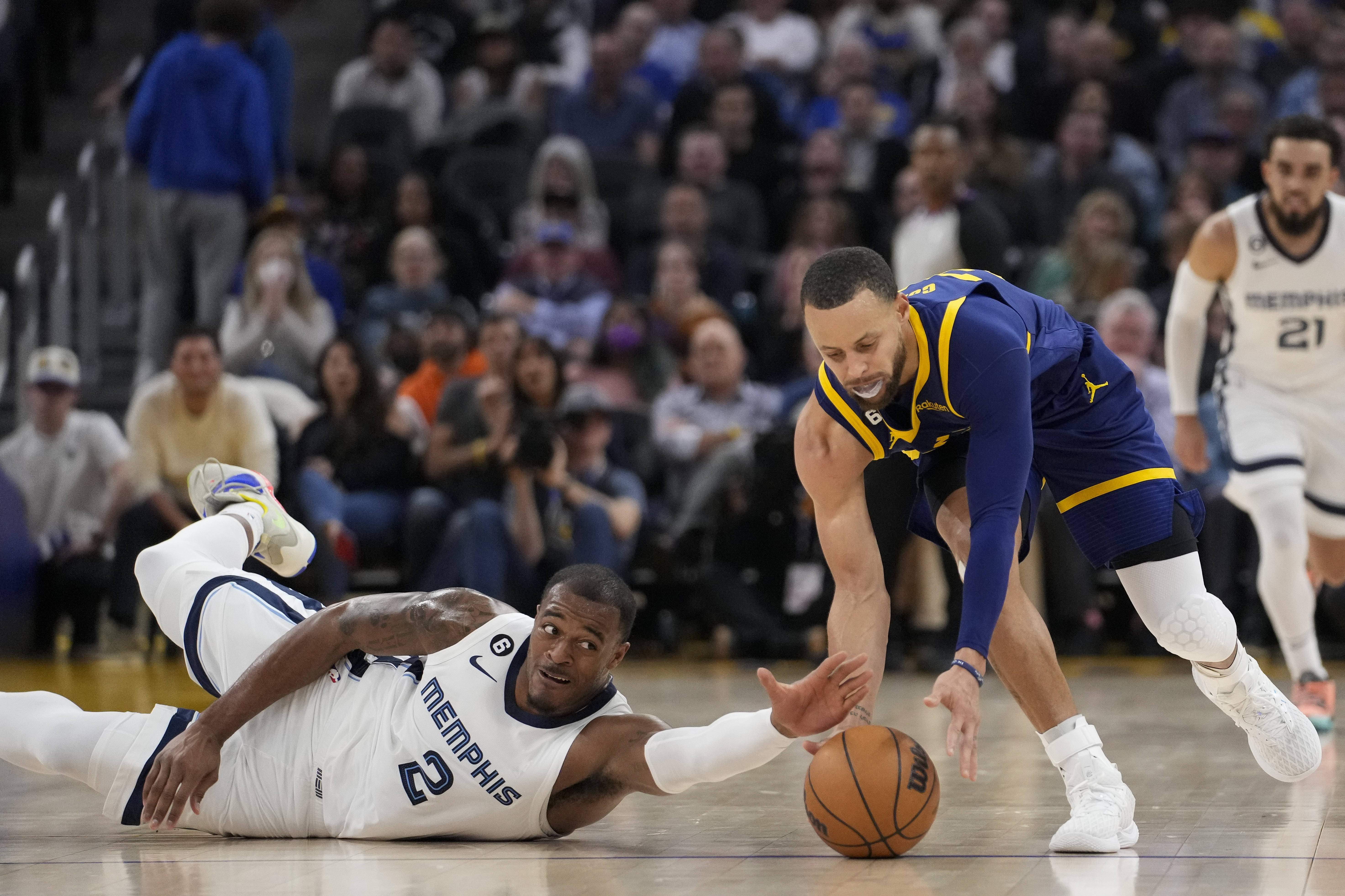 Memphis Grizzlies forward Xavier Tillman Sr., left, and Golden State Warriors guard Stephen Curry compete for possession of the ball during the first half of an NBA basketball game in San Francisco, Wednesday, Jan. 25, 2023. 
