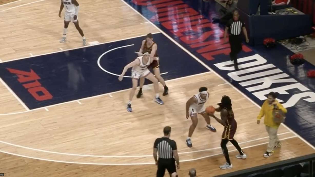 Apparent delivery person walks onto college basketball court.