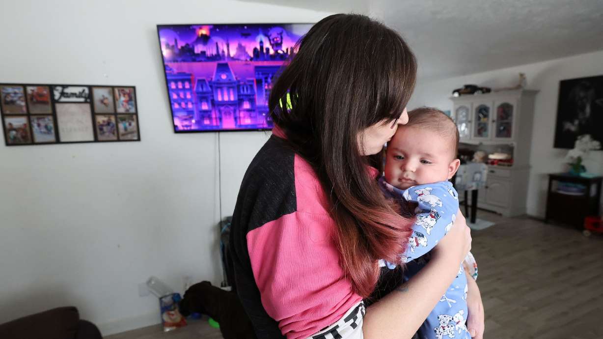 Darlene Wayment kisses her baby Elijah at her home in Ogden on Jan. 24. Wayment has noticed a sharp increase in her utility bill with no increased usage in the past couple months.