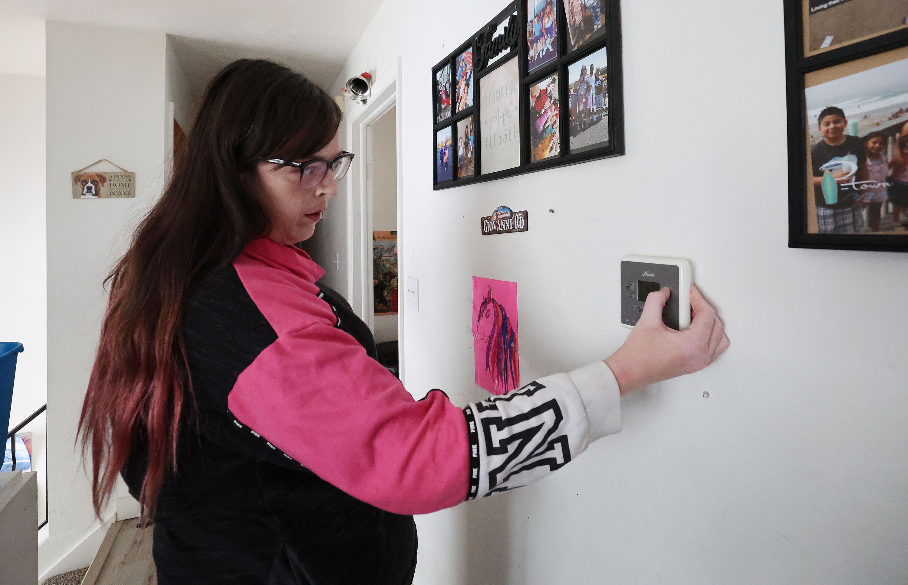 Darlene Wayment adjusts her thermostat at her home in Ogden on Jan. 24. Wayment has noticed a sharp increase in her utility bill with no increased usage in the past couple of months.
