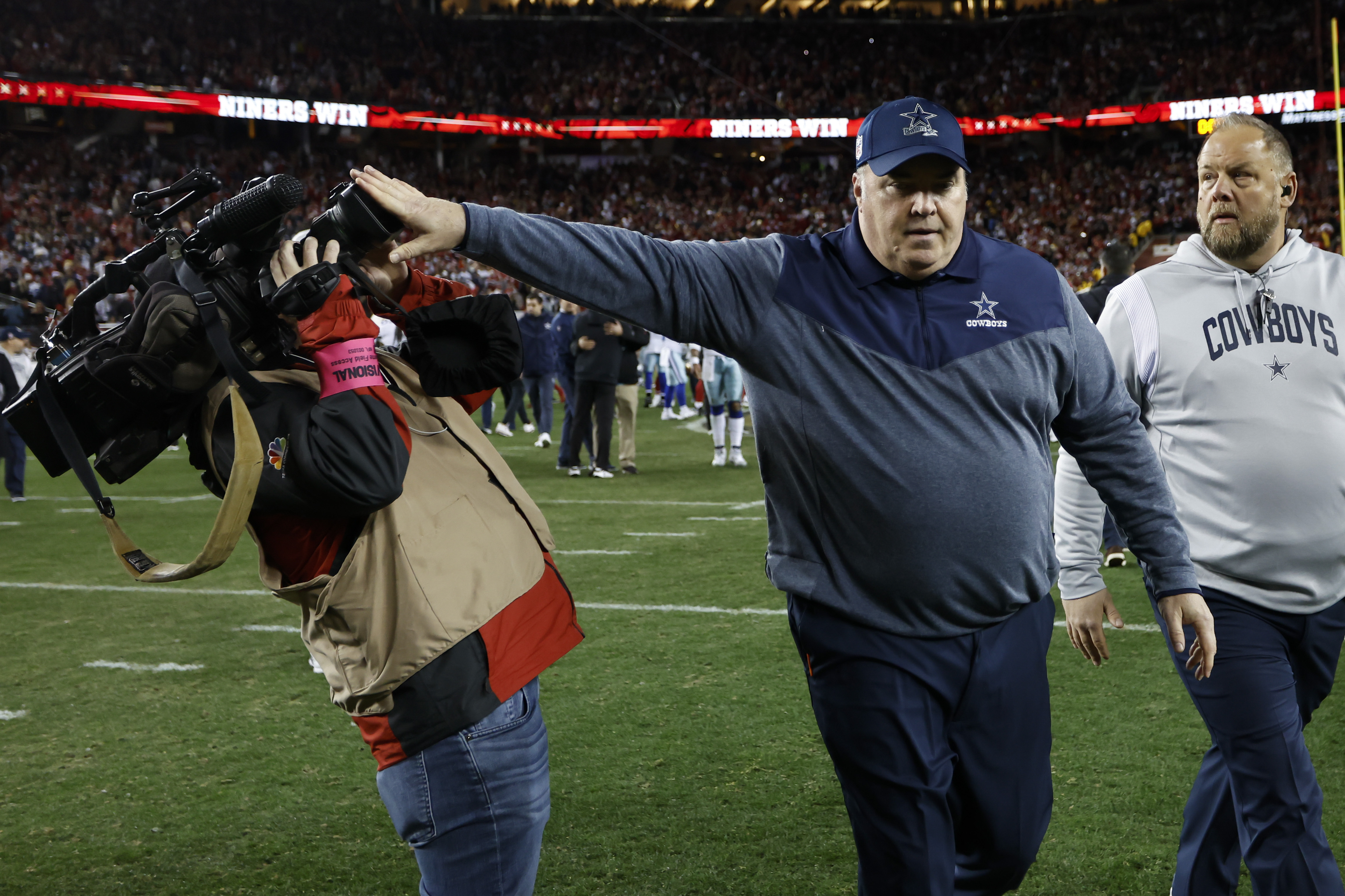 Dallas Cowboys head coach Mike McCarthy pushes a cameraman away while walking off the field after an NFL divisional round playoff football game against the San Francisco 49ers in Santa Clara, Calif., Sunday, Jan. 22, 2023. 