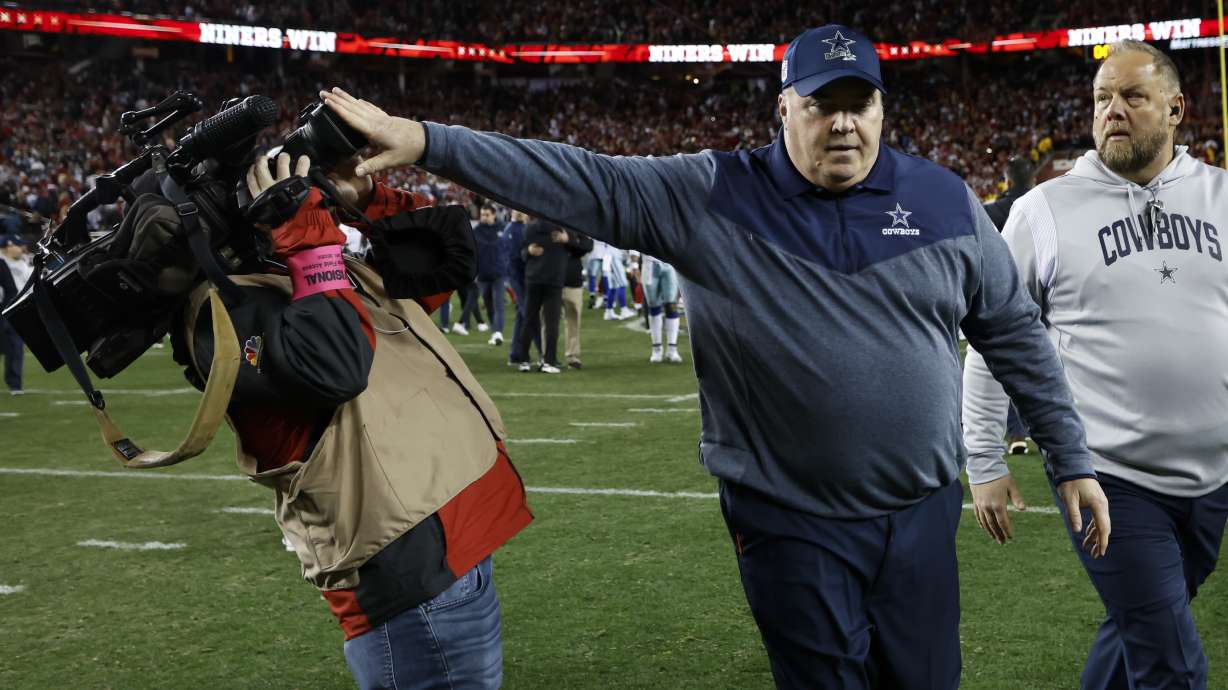 Dallas Cowboys head coach Mike McCarthy pushes a cameraman away while walking off the field after an NFL divisional round playoff football game against the San Francisco 49ers in Santa Clara, Calif., Sunday, Jan. 22, 2023.