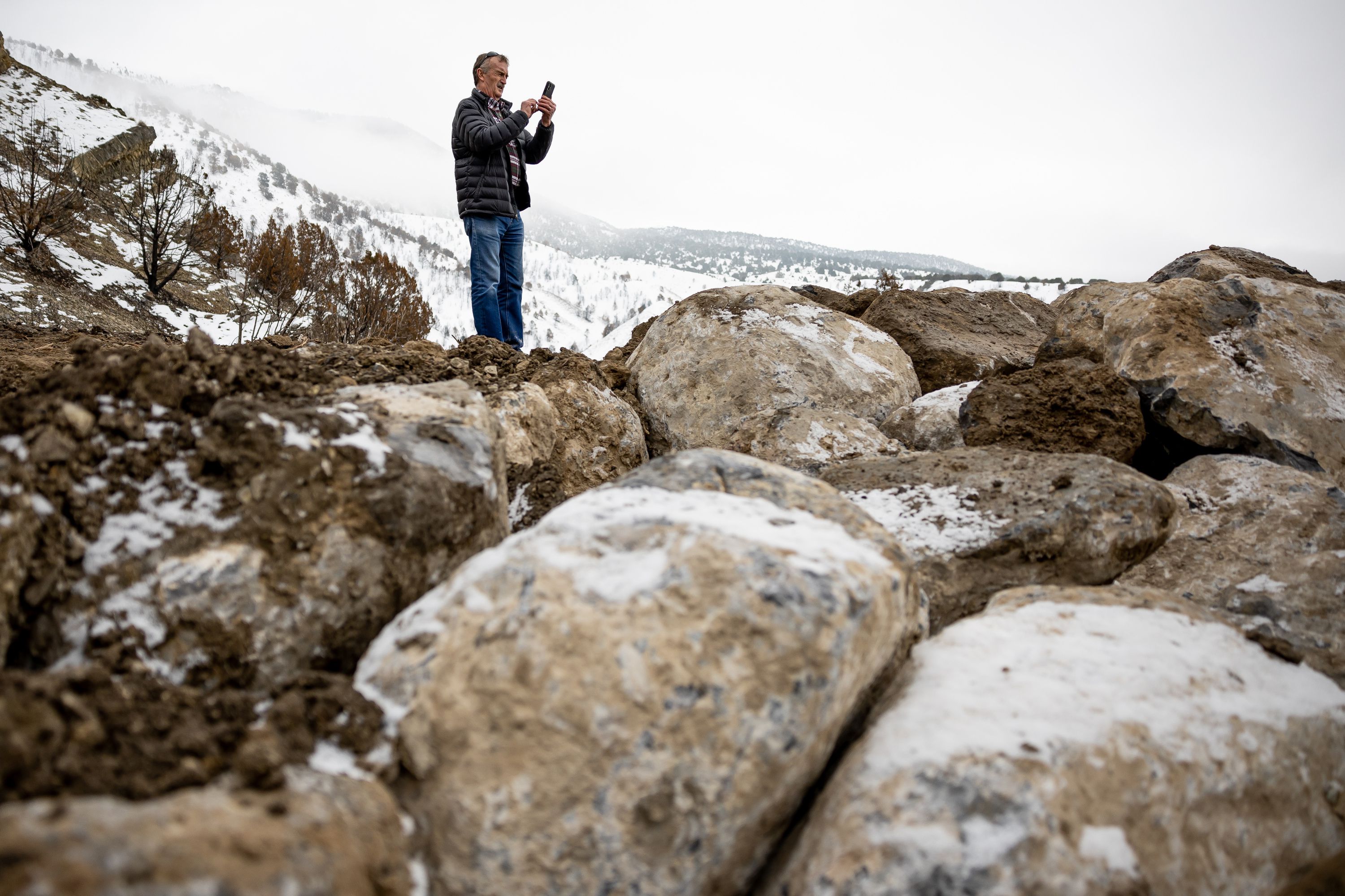 Nando Meli, mayor of the town of Stockton in Tooele County, takes a photo of a berm being constructed with emergency funds to protect the town’s water treatment plant on Thursday.