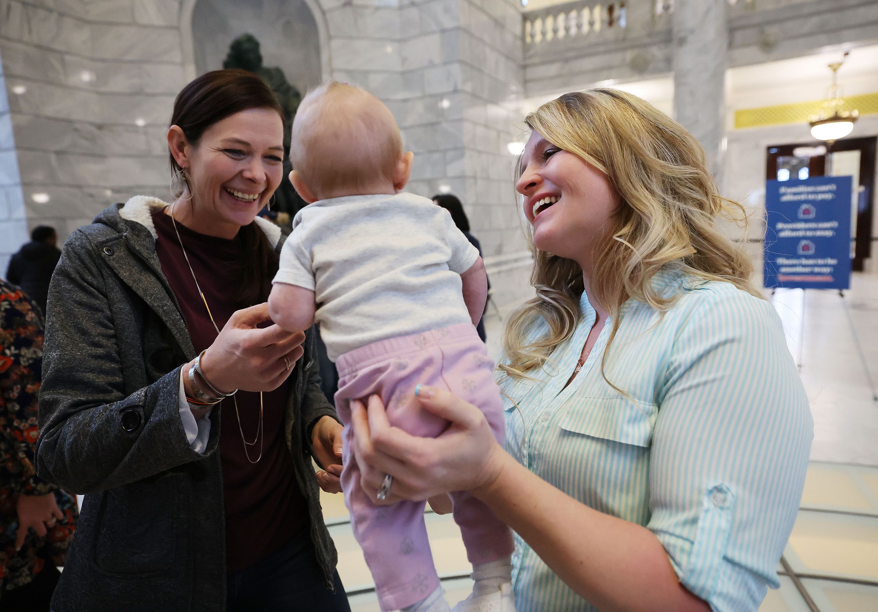 Child care provider Holly Kingston holds her daughter Haisley and talks with Ilse Wilson in the Rotunda at the Capitol in Salt Lake City on Friday. Parents, children, educators and supporters gathered at the Capitol for Child Care Day on the Hill.