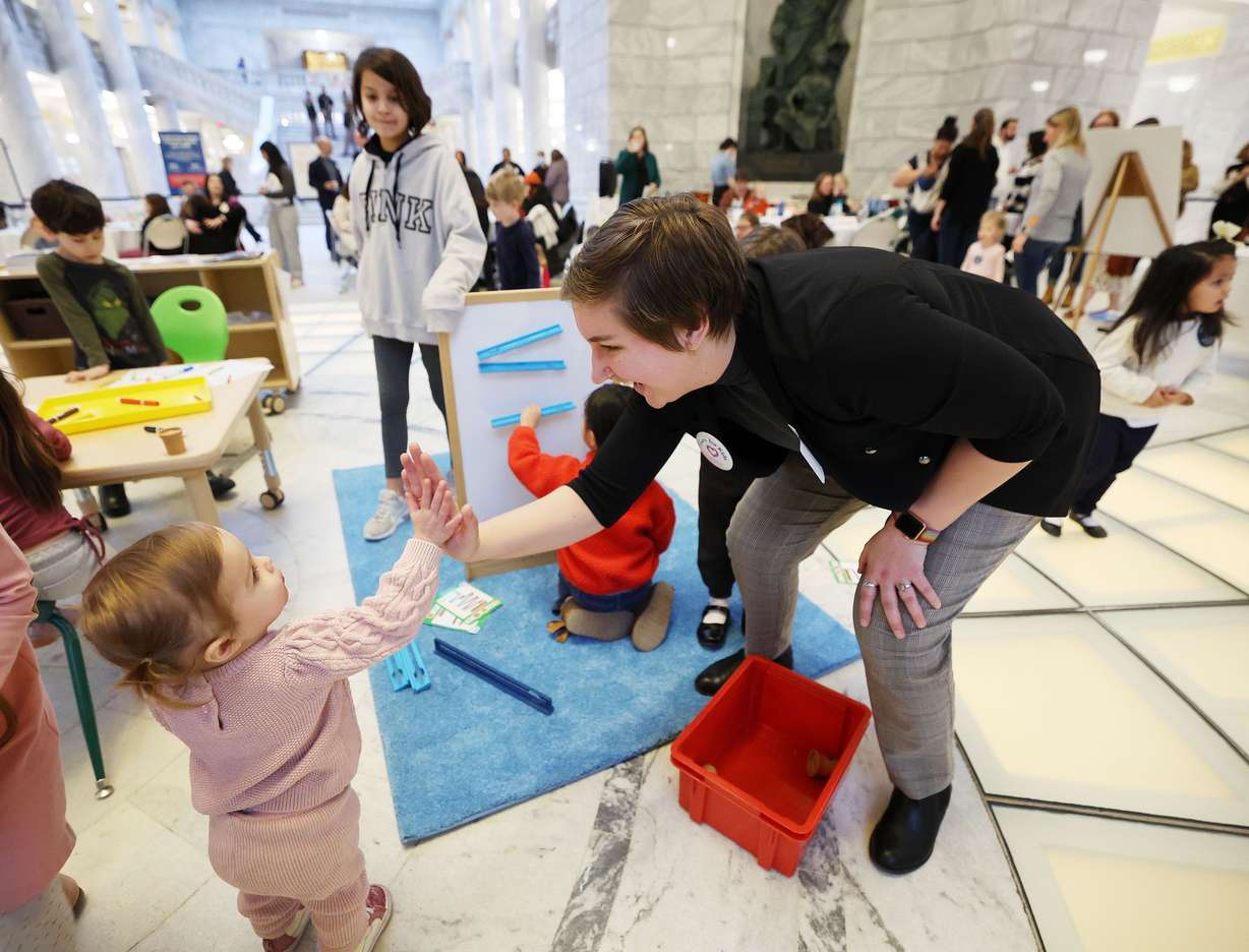 Child care provider Sydney Spray plays with children in the rotunda at the Capitol in Salt Lake City on Friday. Parents, children, educators and supporters gathered at the Capitol for Child Care Day on the Hill.
