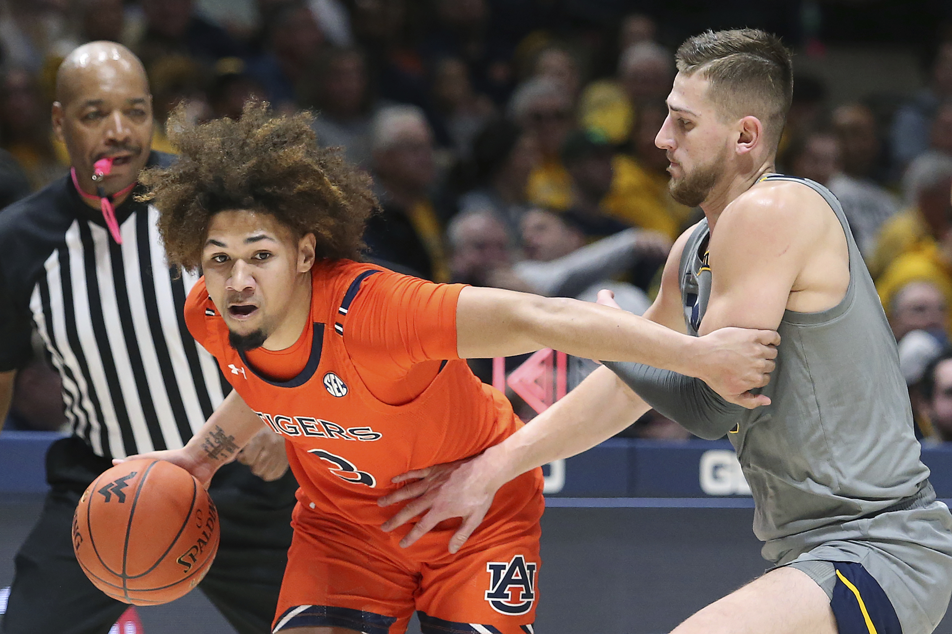 Auburn guard Tre Donaldson (3) is defended by West Virginia guard Erik Stevenson during the first half of an NCAA college basketball game on Saturday, Jan. 28, 2023, in Morgantown, W.Va. 