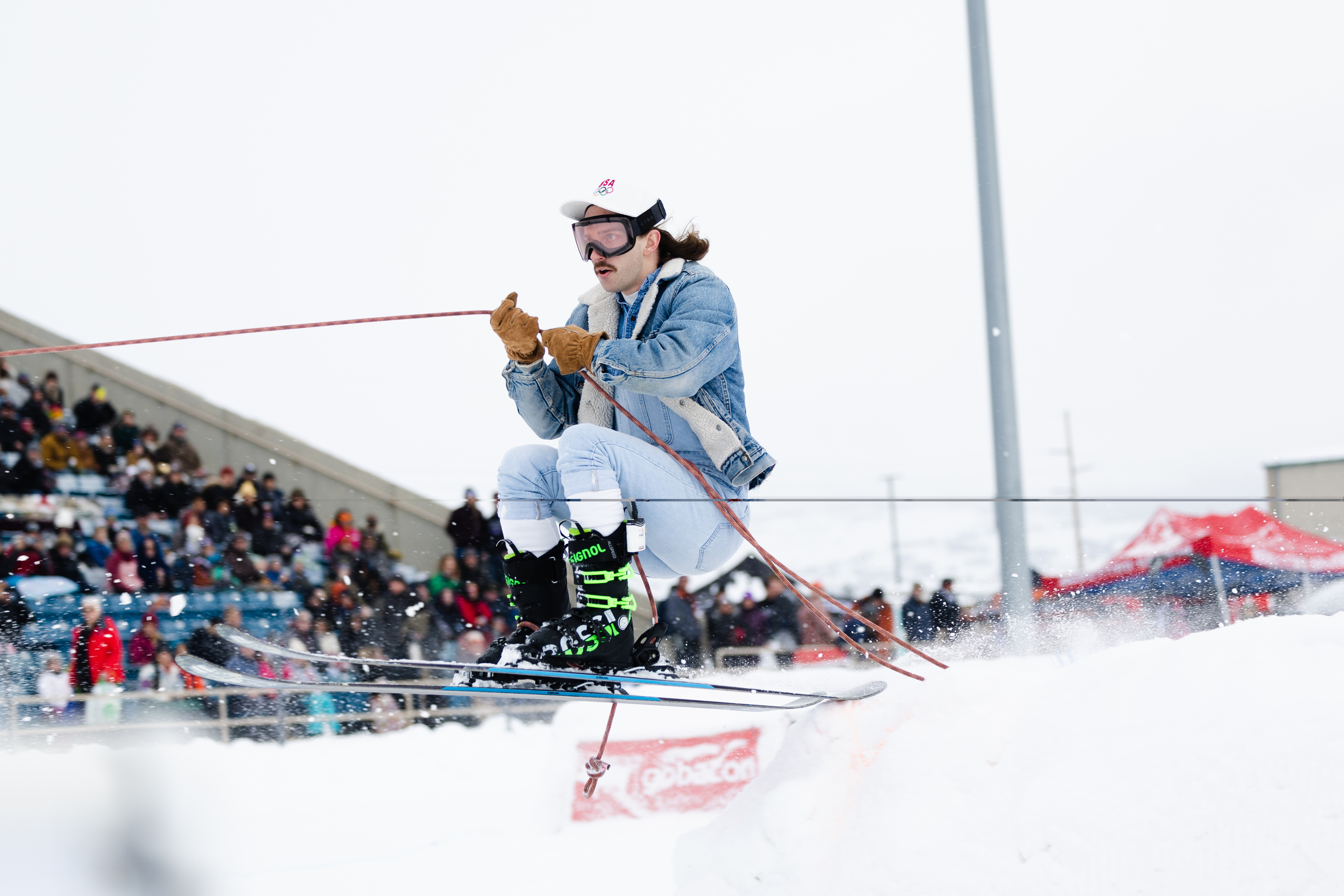 A participant makes a jump during a skijoring competition at the Wasatch County Events Center in Heber City on Saturday.