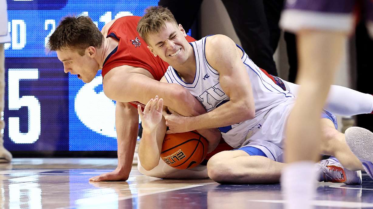 Saint Mary's Gaels center Mitchell Saxen (11) and Brigham Young guard Dallin Hall (30) wrestle for the ball as BYU and Saint Mary’s play at the Marriott Center in Provo on Saturday, Jan. 28, 2023. The Gaels won 57-56.