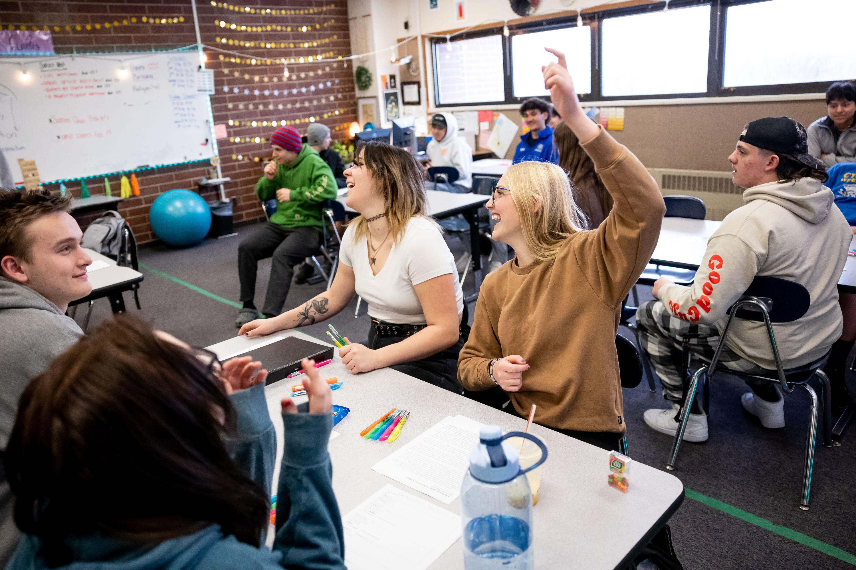 Tori Poulsen, 18, center, and Lily Williams, 17, right, laugh during a review game being played in their English class at Cyprus High School in Magna on Friday.