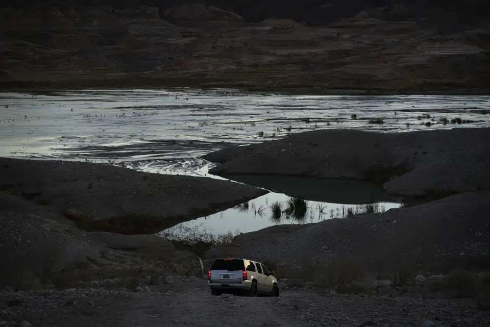 A car drives along a dirt road near Lake Mead at the Lake Mead National Recreation Area, Friday near Boulder City, Nev. More than 10% of the water carried by the Colorado River evaporates, leaks or spills as the 1,450-mile powerhouse river of the West flows through the region’s dams, reservoirs and open-air canals.