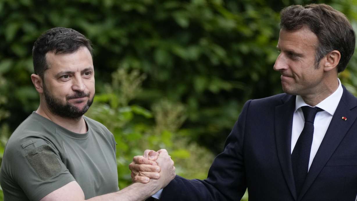 Ukraine President Volodymyr Zelenskyy, left, and France’s President Emmanuel Macron shake hands in Kyiv, Ukraine, June 16, 2022. The question of if and how Russia competes at the Olympics hangs over the 2024 Paris Summer Games.