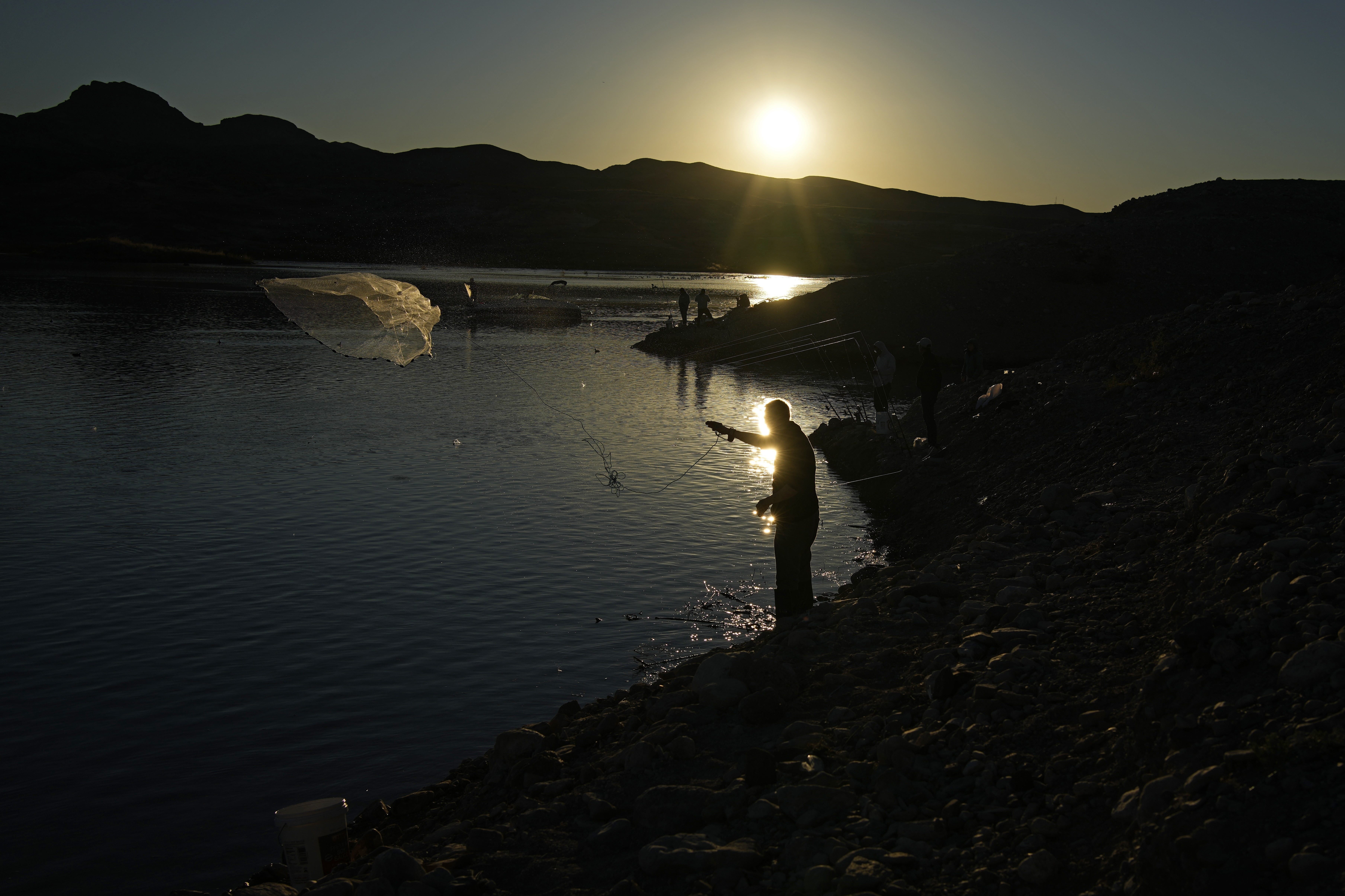 A fisherman throws a cast net along shore of Lake Mead at the Lake Mead National Recreation Area, Friday near Boulder City, Nev. Six western states that rely on water from the Colorado River have agreed on a plan to dramatically cut their use.