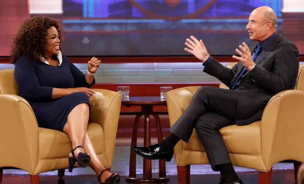 This Sept. 22, 2015, photo shows Oprah Winfrey, left, and Dr. Phil McGraw on the set of the "Dr. Phil," talk show. McGraw says he'll stop making new episodes of his daytime TV show after 21 years this spring.