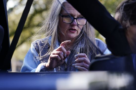 Jessie Blanchard, center, shows a participant how to use a straight pipe as she hands out other goods like food, Naloxone, needles, tourniquets, and condoms to members of the community on Jan. 23 in Albany, Ga.