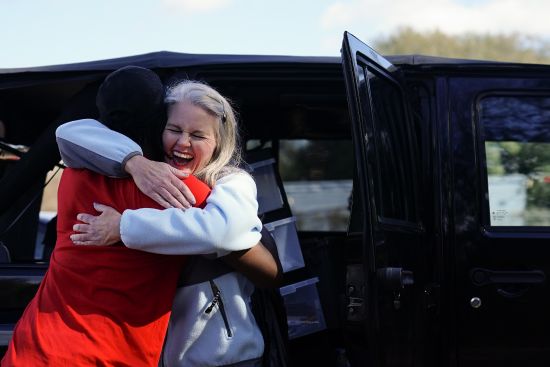 Jessie Blanchard, center, kisses and hugs a participant who arrived to receive help with food, naloxone, needles, tourniquets, condoms and other goods on Jan. 23 in Albany, Ga.