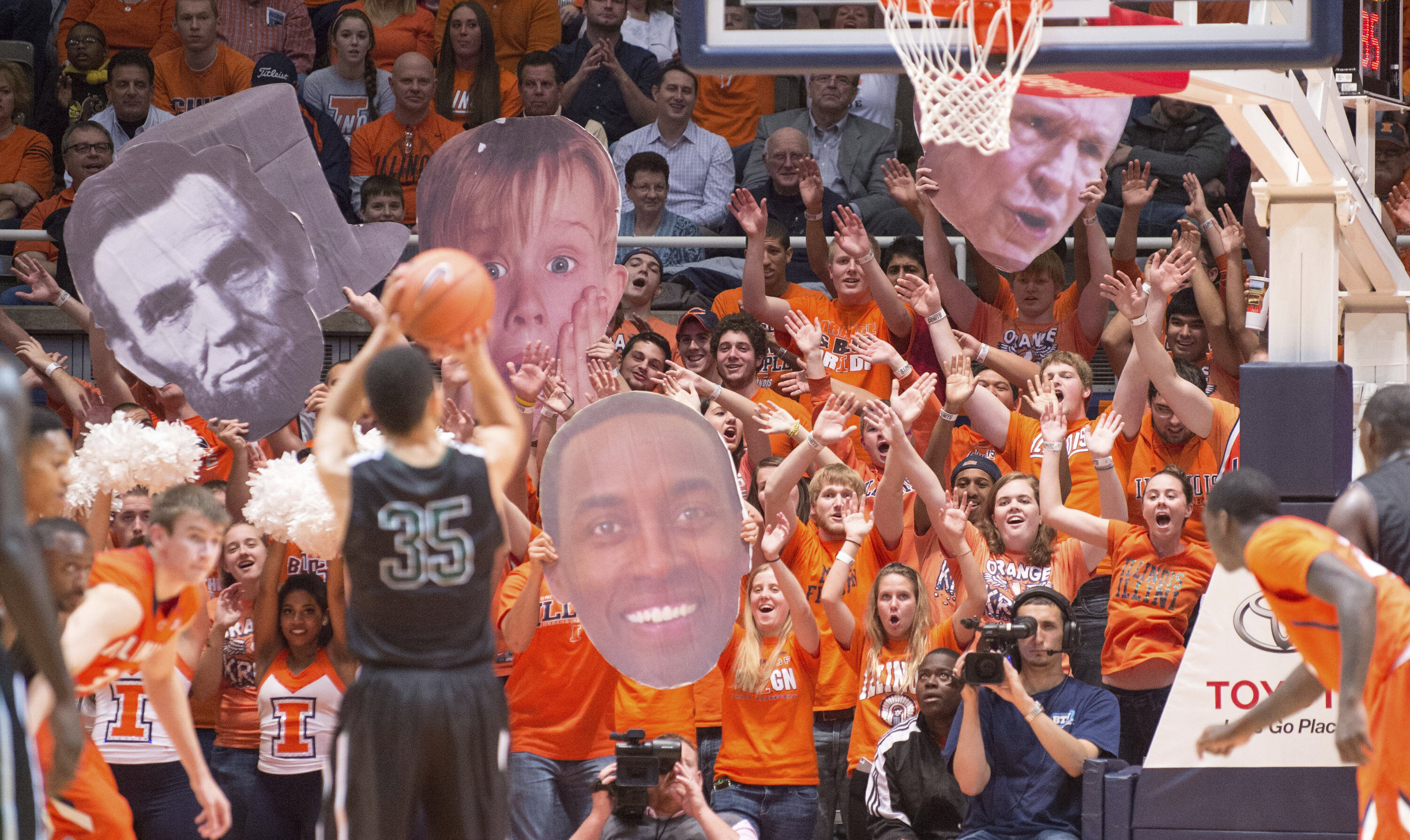 FILE - The Illinois Orange Krush student section uses large heads to heckle Chicago State's Clarke Rosenberg (35) as he tries for a foul shot during the second half of an NCAA college basketball game on Nov. 22, 2013, in Champaign, Ill. The Illinois student spirit group “Orange Krush” had its order for 200 tickets to the men's basketball game at Carver-Hawkeye Arena on Saturday, Feb. 4, 2023, canceled, after Iowa discovered the person who made the purchase falsely claimed the tickets were for a Boys and Girls Club. 
