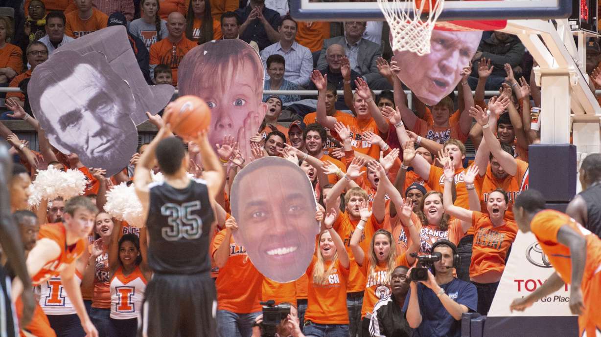 FILE - The Illinois Orange Krush student section uses large heads to heckle Chicago State's Clarke Rosenberg (35) as he tries for a foul shot during the second half of an NCAA college basketball game on Nov. 22, 2013, in Champaign, Ill. The Illinois student spirit group “Orange Krush” had its order for 200 tickets to the men's basketball game at Carver-Hawkeye Arena on Saturday, Feb. 4, 2023, canceled, after Iowa discovered the person who made the purchase falsely claimed the tickets were for a Boys and Girls Club.