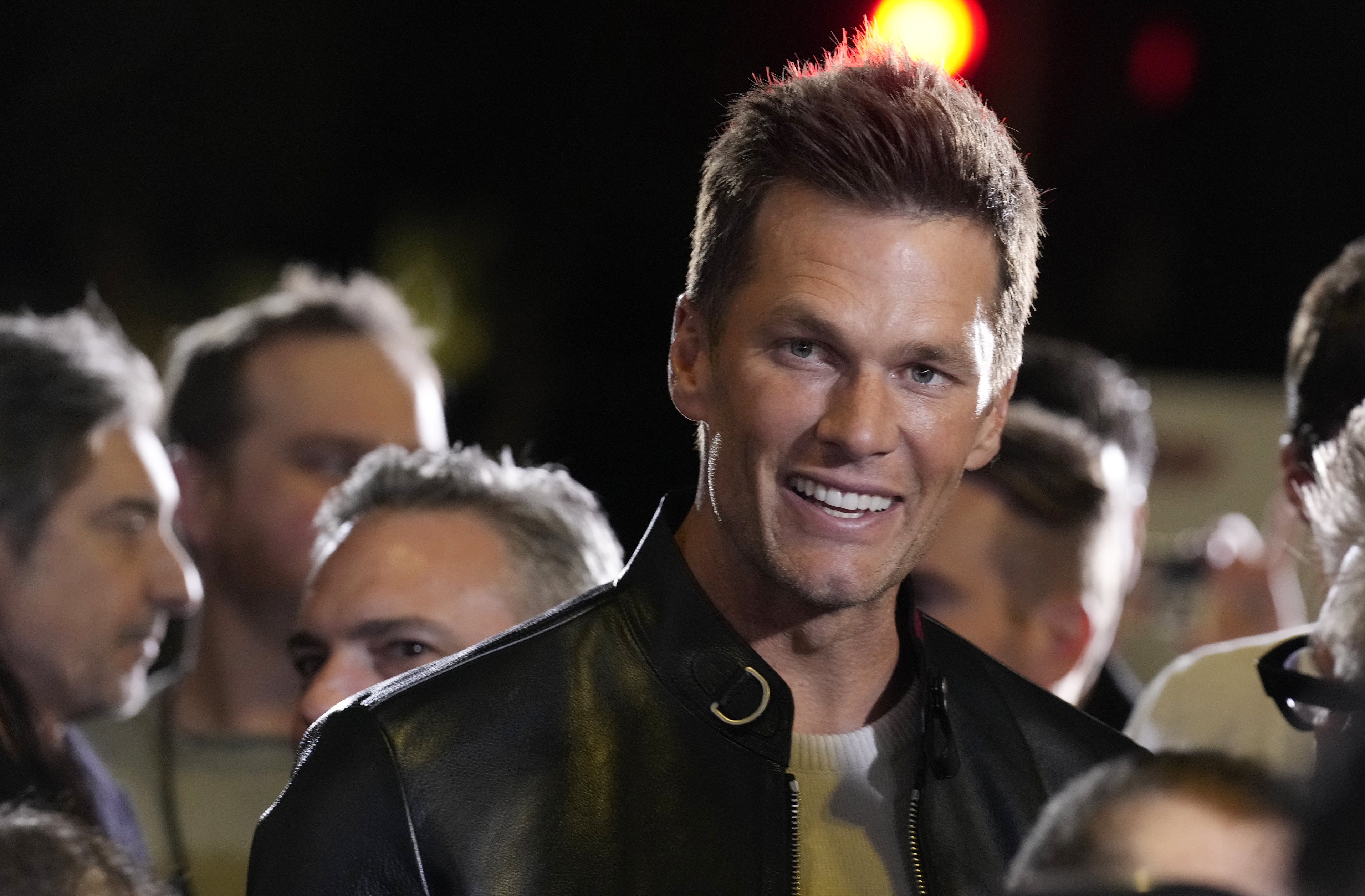 NFL quarterback Tom Brady, a cast member and producer of "80 for Brady," looks down the carpet at the premiere of the film, Tuesday, Jan. 31, 2023, at the Regency Village Theatre in Los Angeles. 