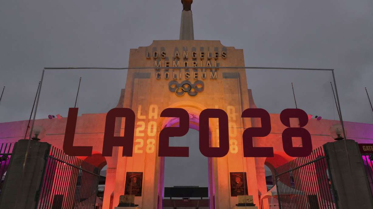 An LA 2028 sign is seen in front of a blazing Olympic cauldron at the Los Angeles Memorial Coliseum on Sept. 13, 2017. Whether Russian athletes compete in 2024 could impact future Olympic Games, experts say.