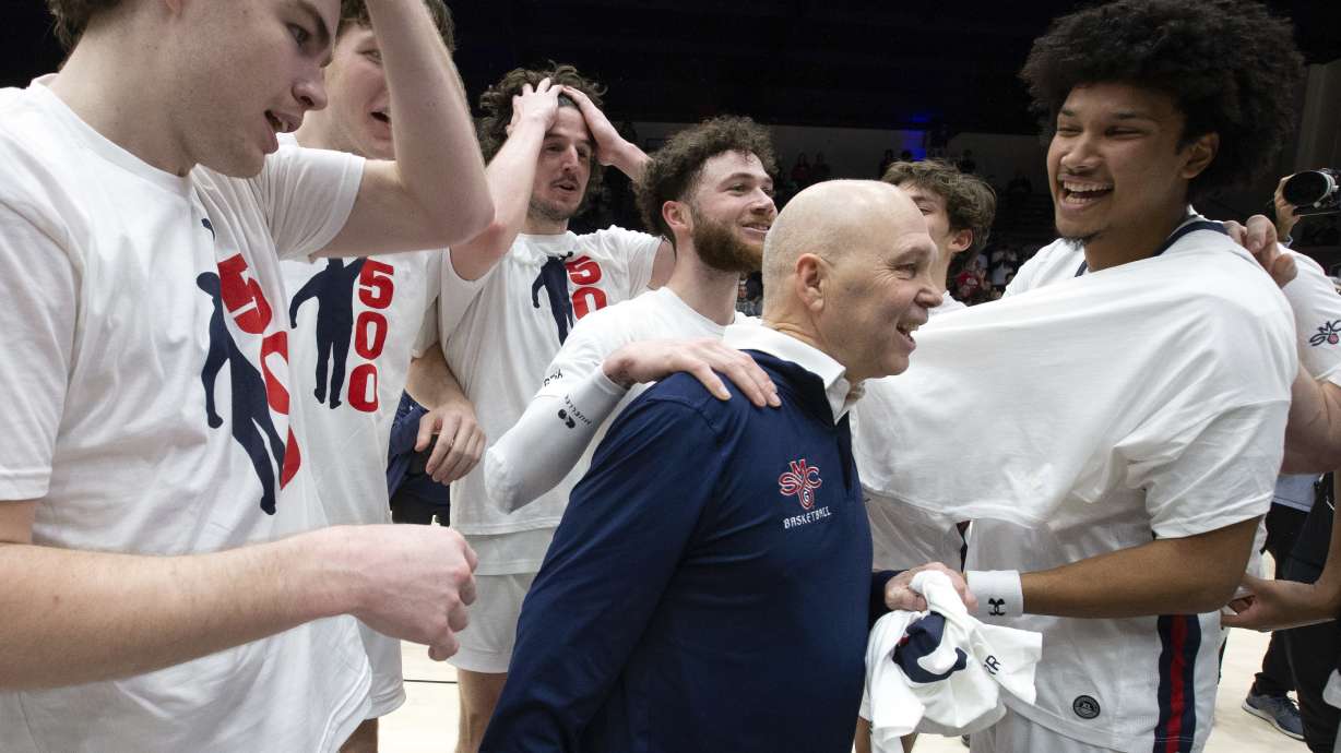 Saint Mary's head coach Randy Bennett, center, is congratulated by his players after notching his 500th career coaching victory, with a 68-59 victory over San Francisco in an NCAA college basketball game, Thursday, Feb. 2, 2023, in Moraga, Calif.
