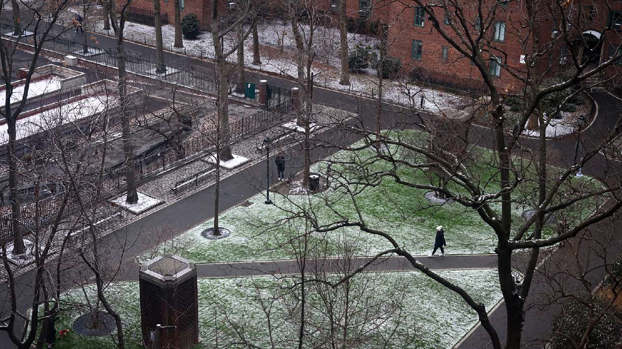 A person walks through a park following the first measurable snowfall of the season, breaking a 50-year record, in New York City on Feb. 1. A brutal blast of dangerously cold winds is expected to sweep across the Northeast and New England on Friday, prompting officials to close schools and activate emergency plans.