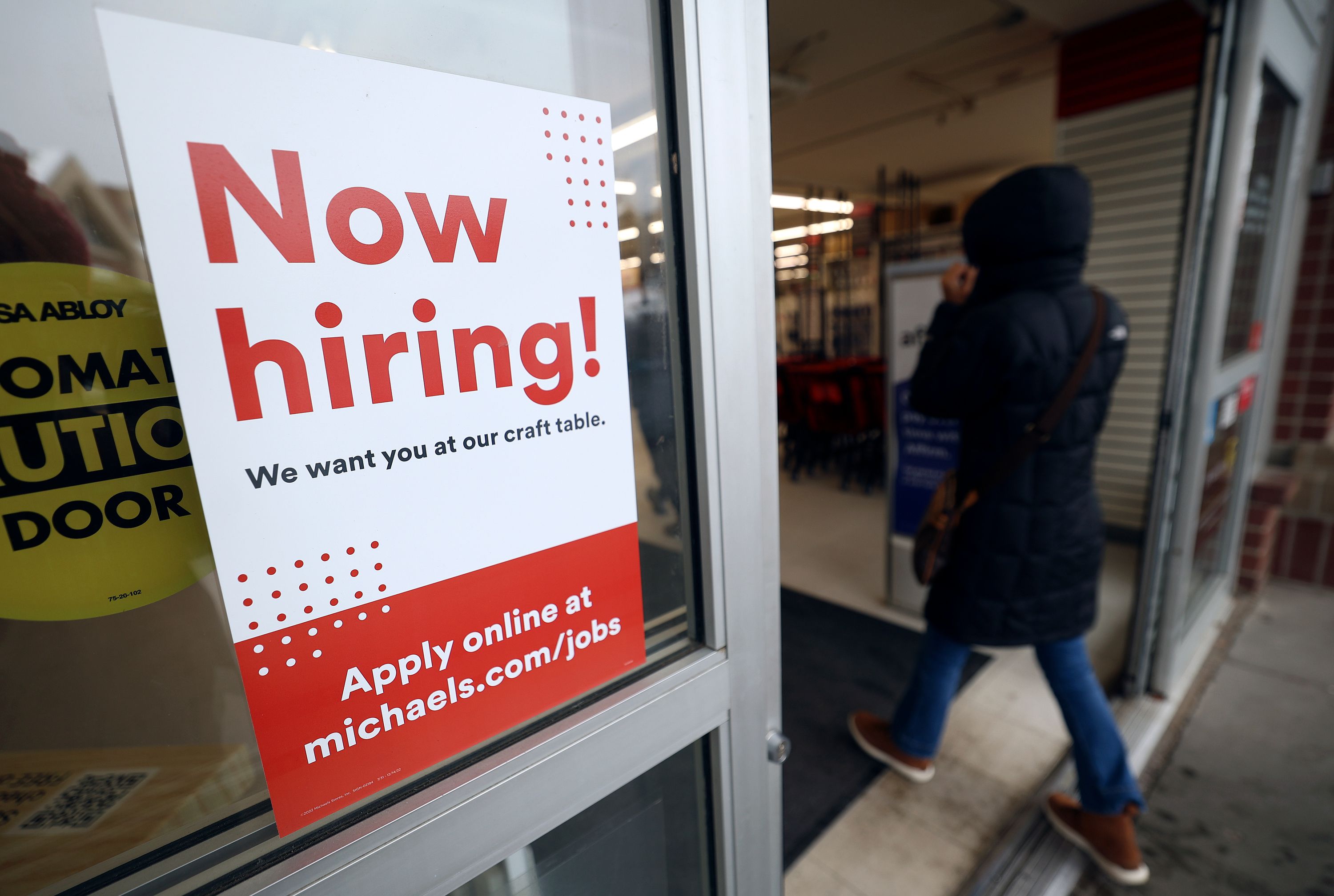A “Now hiring!” sign is pictured on the door to Michaels in Salt Lake City on Jan. 6. A significant boost in new job growth is hard for analysts to explain.