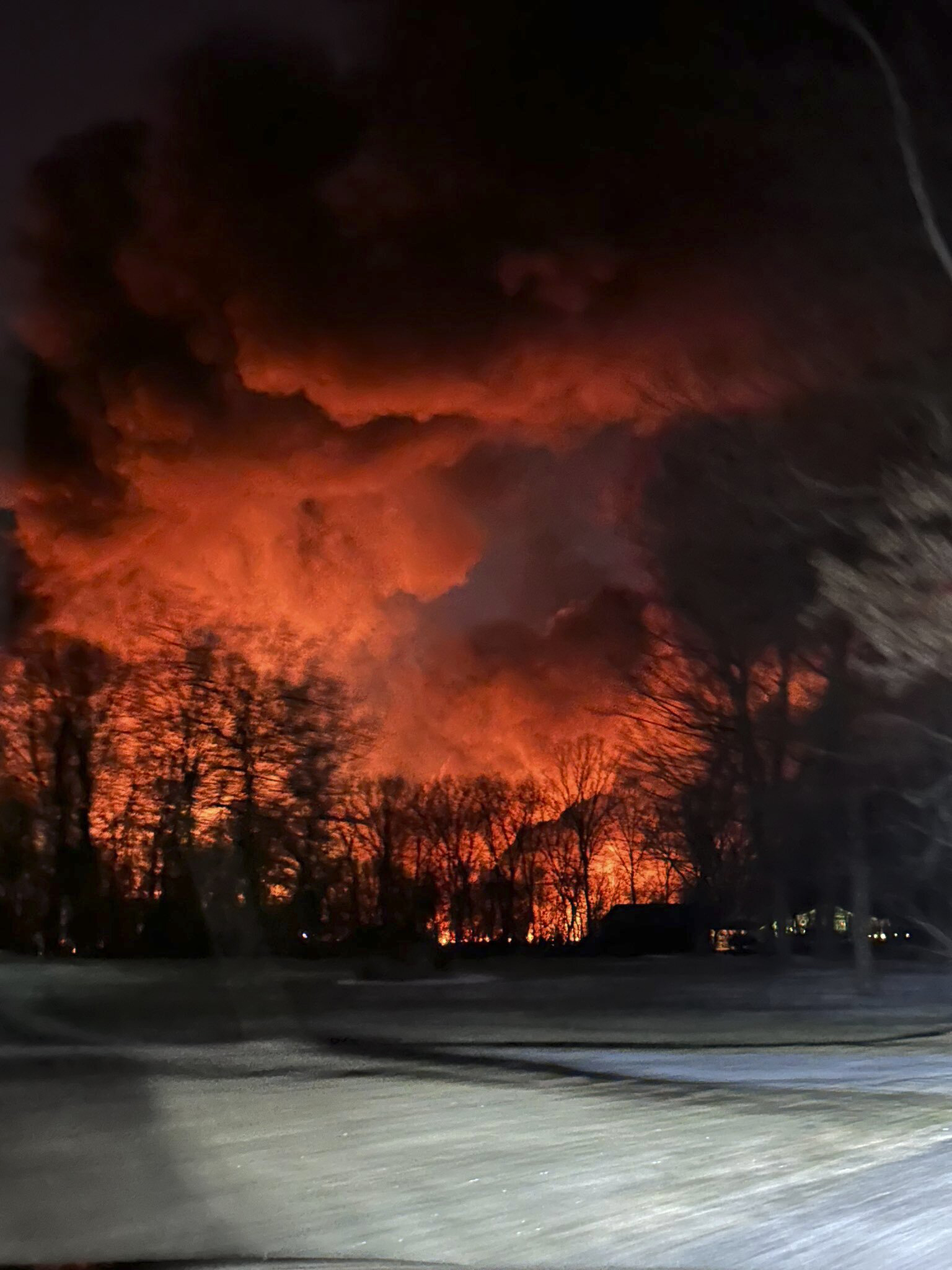 In this photo provided by Melissa Smith, a train fire is seen from her farm in East Palestine, Ohio, Friday. A train derailment and resulting large fire prompted an evacuation order in the Ohio village near the Pennsylvania state line on Friday night, covering the area in billows of smoke lit orange by the flames below.