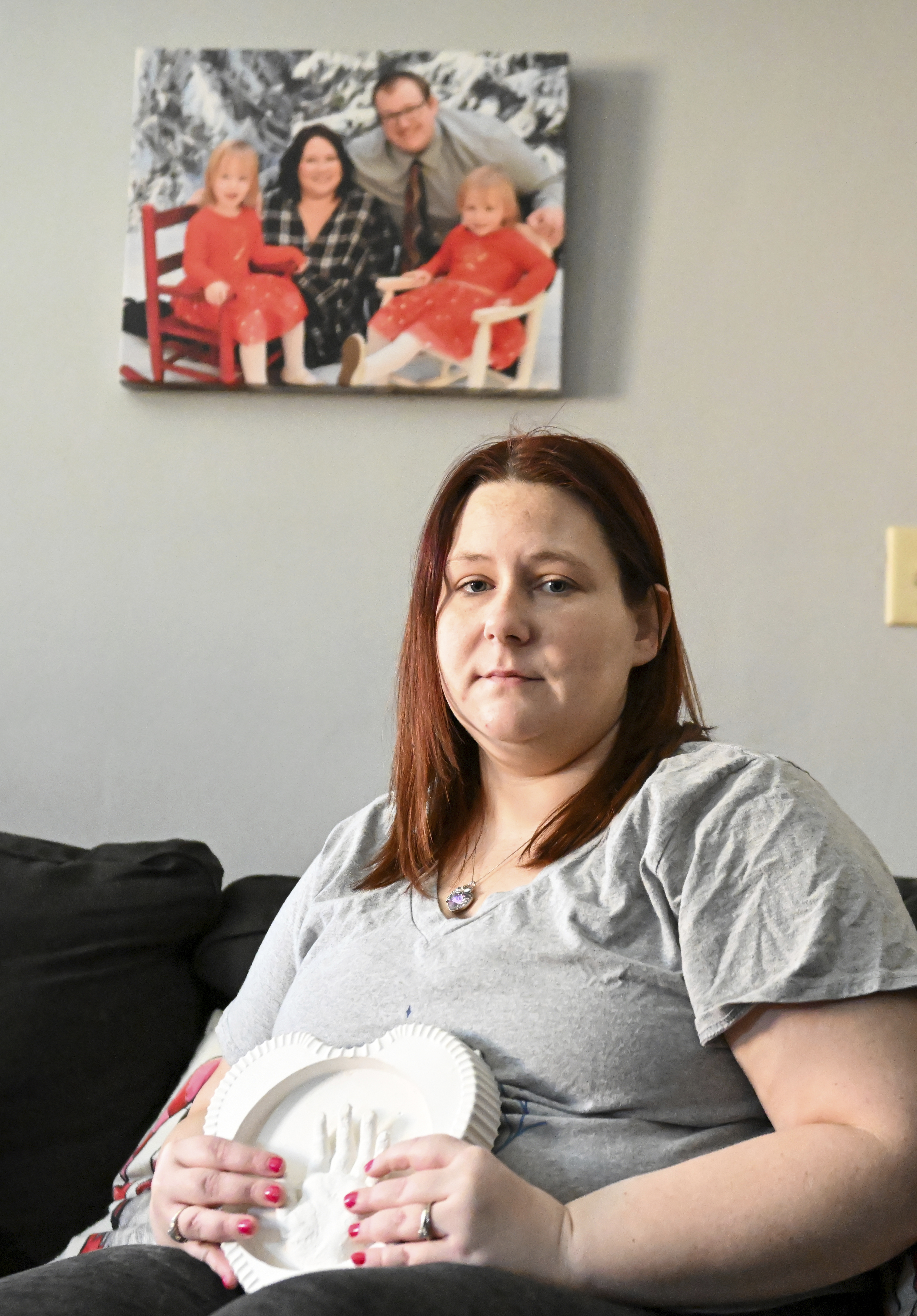 Jessica Day-Weaver holds a ceramic hand print of her daughter, Anastasia, at her home, Thursday, in Boardman, Ohio.