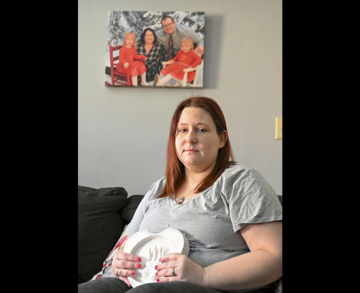 Jessica Day-Weaver holds a ceramic hand print of her daughter, Anastasia, at her home, Thursday, in Boardman, Ohio.