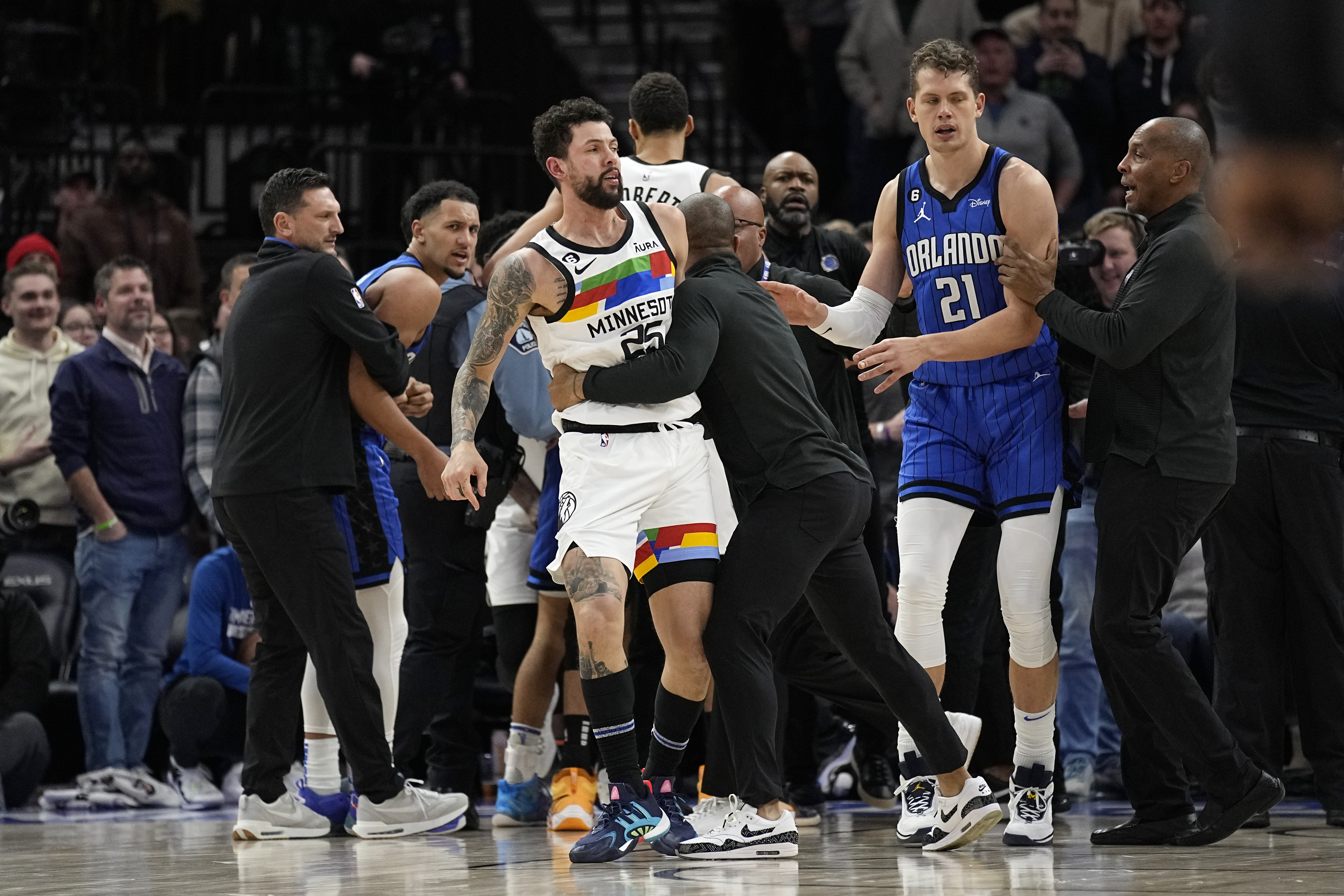 Minnesota Timberwolves guard Austin Rivers, middle, is held back after participating in a scrum with Orlando Magic players during the second half of an NBA basketball game, Friday, Feb. 3, 2023, in Minneapolis. 