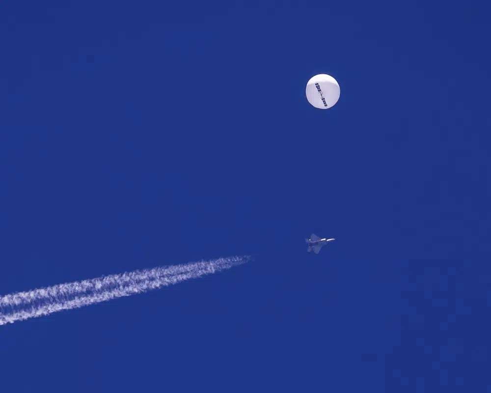 A large balloon drifts above the Atlantic Ocean, just off the coast of South Carolina, with a fighter jet and its contrail seen below it, Saturday. The balloon was struck by a missile from an F-22 fighter just off Myrtle Beach, fascinating sky-watchers across a populous area known as the Grand Strand for its miles of beaches that draw retirees and vacationers.