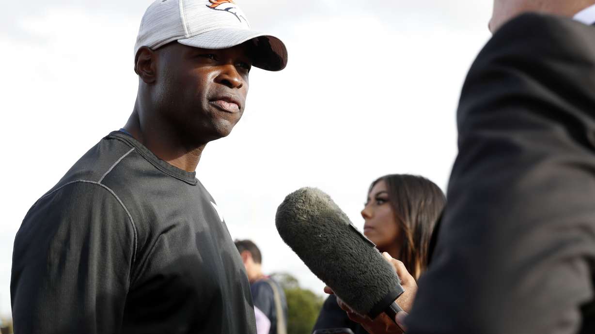 FILE - Denver Broncos defensive coordinator Ejiro Evero, left, speaks with media after a practice session in Harrow, England, Oct. 28, 2022. The Carolina Panthers have agreed to terms with Evero to be their new defensive coordinator.