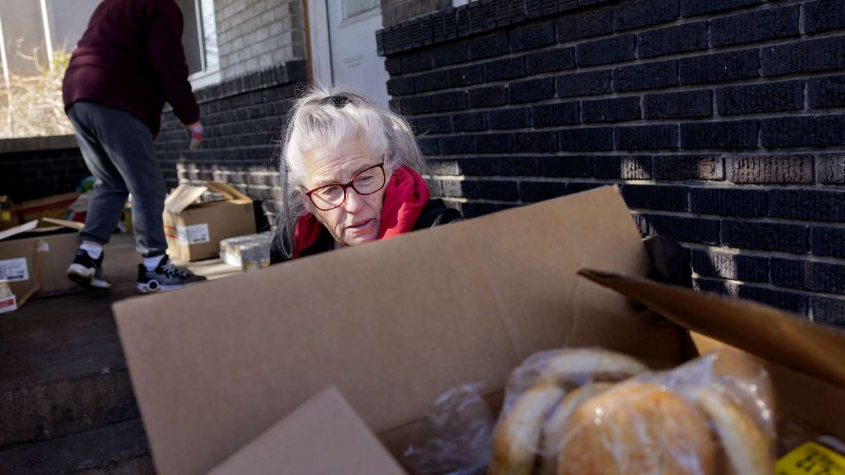 Shauna Devenport unloads a box of bread products onto her porch in Salt Lake City on Jan. 31. Devenport has been gathering and placing donated food items on her porch, six days a week, for more than thirty years.