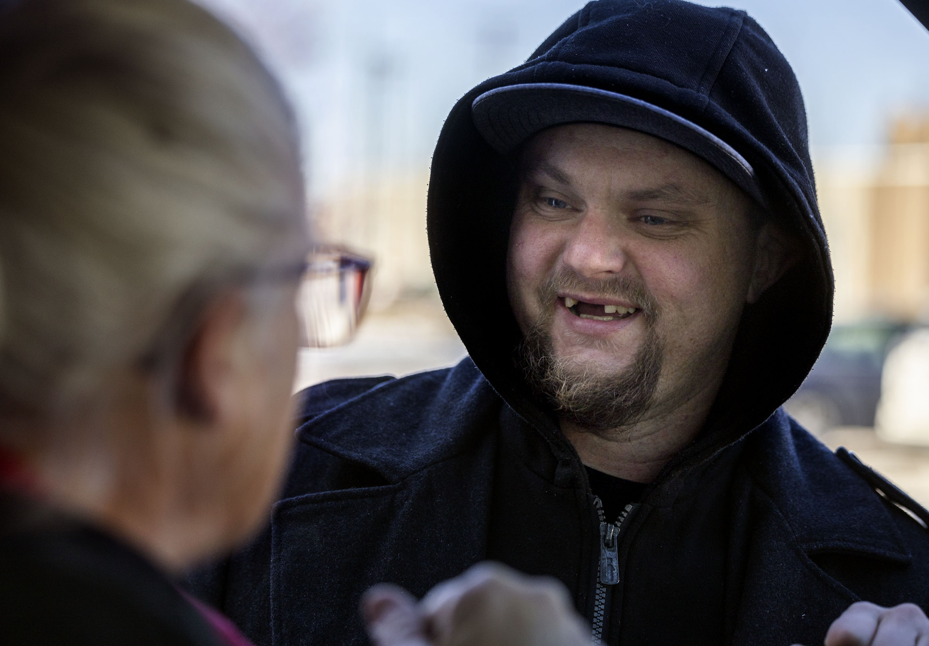 A Rescue Mission resident chats with Shauna Devenport after loading her van with used clothing that she will put on her porch in Salt Lake City on Jan. 30.