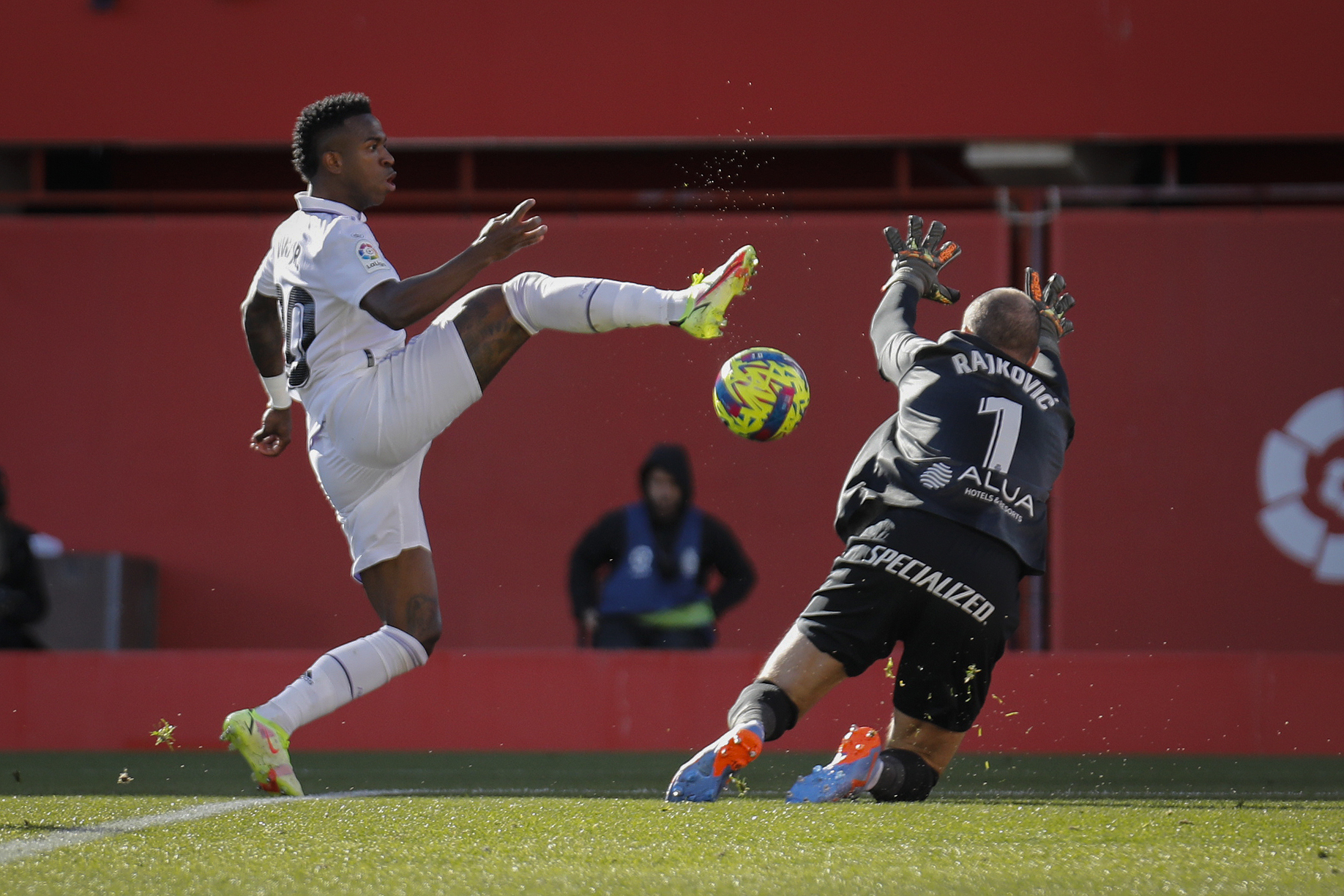 Real Madrid's Vinicius Junior, left, in action against Mallorca's goalkeeper Predrag Rajkovic during a Spanish La Liga soccer match between Mallorca and Real Madrid at the Son Moix stadium in Palma de Mallorca, Spain, Sunday, Feb. 5, 2023. 