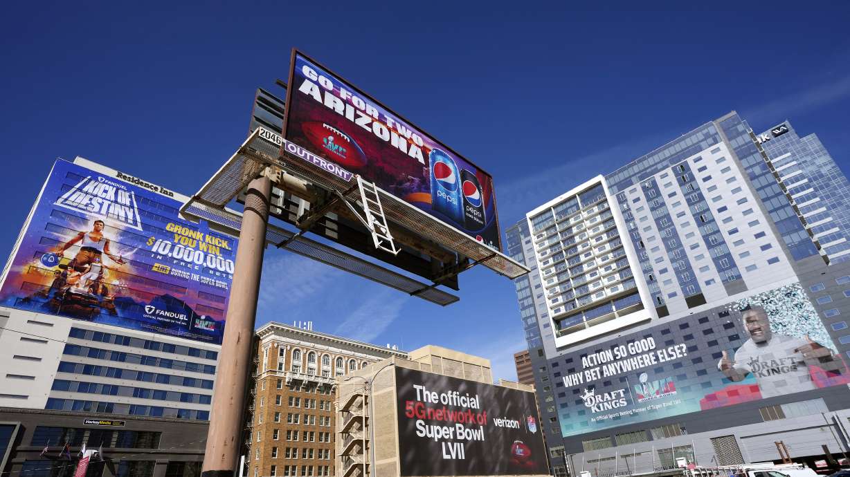 Large advertisements adorn buildings and electronic billboards leading up to the NFL Super Bowl LVII football game in Phoenix, Friday.