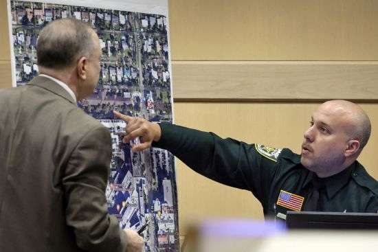 Palm Beach Sheriff's Office Deputy Xavier Pastrana Santiago shows where patients from the Rehabilitation Center at Hollywood Hills were evacuated when the nursing home lost air-conditioning due to a power outage, at the Broward County Courthouse in Fort Lauderdale, Fla., Monday.