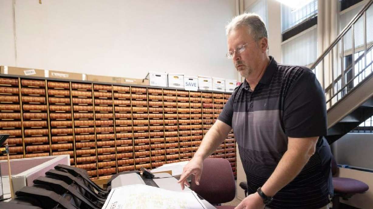 Map preservationist Ron Koch stands beside the scanner he used to digitize the original document in the records office at the Woodbury County Courthouse in Sioux City, Iowa, on Jan 17.